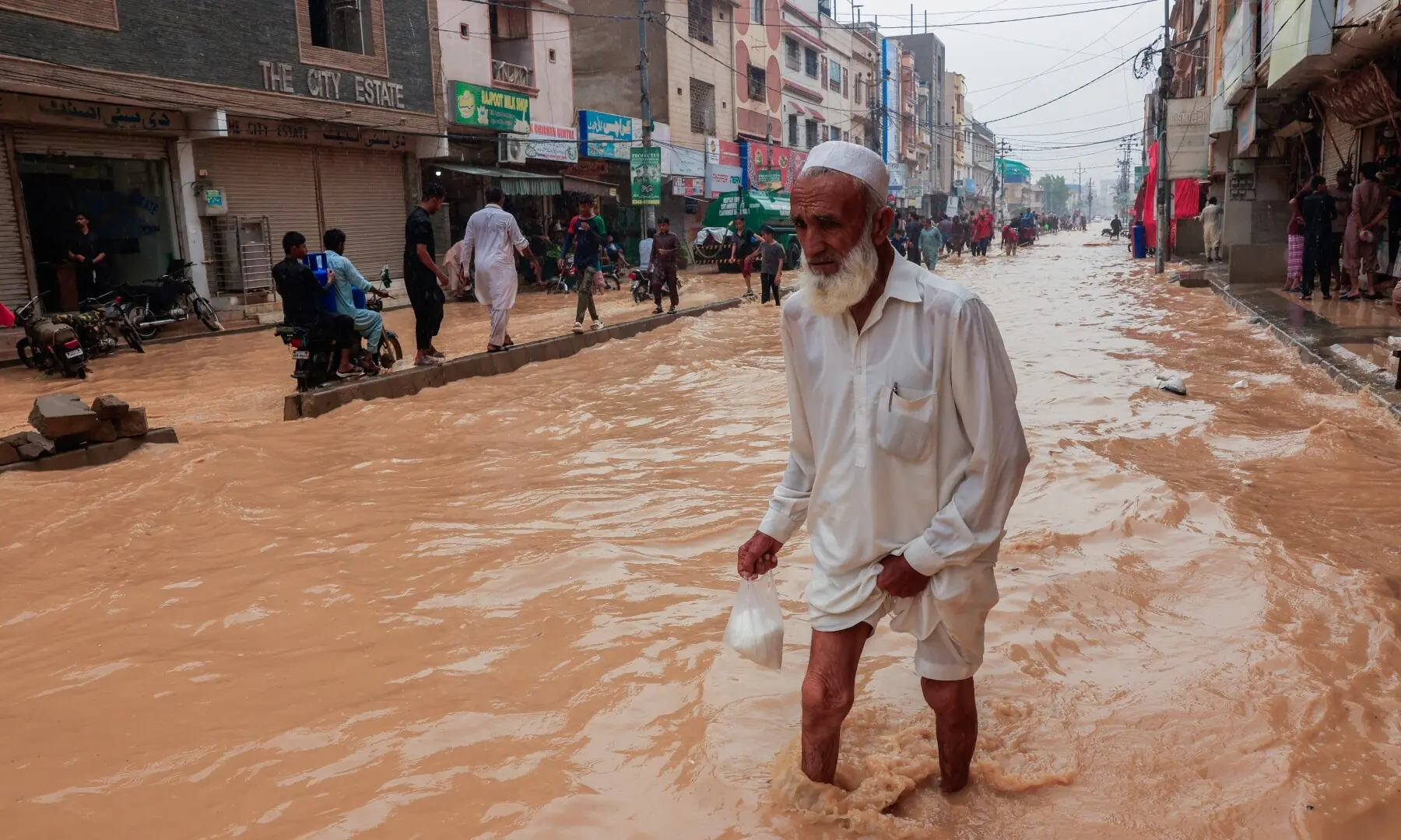 A resident wades through a flooded street after a rain, following a recent monsoon season, in Karachi on Sept 10, 2025. &mdash; Reuters/Akhtar Soomro