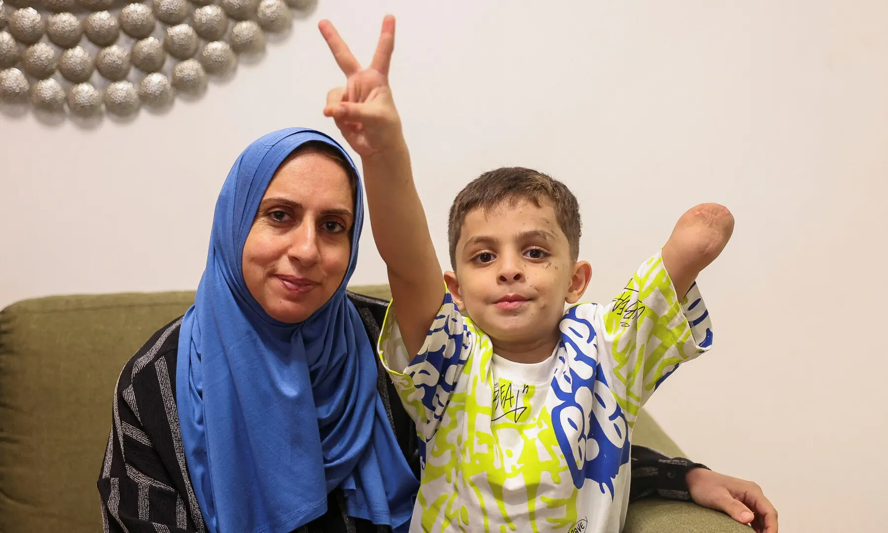 Omar Abu Kuwaik, a six-year-old child who lost an arm, with his aunt in the apartment where they stay during his medical treatment in Beirut.—Reuters Omar Abu Kuwaik, a six-year-old child who lost an arm, with his aunt in the apartment where they stay during his medical treatment in Beirut.—Reuters