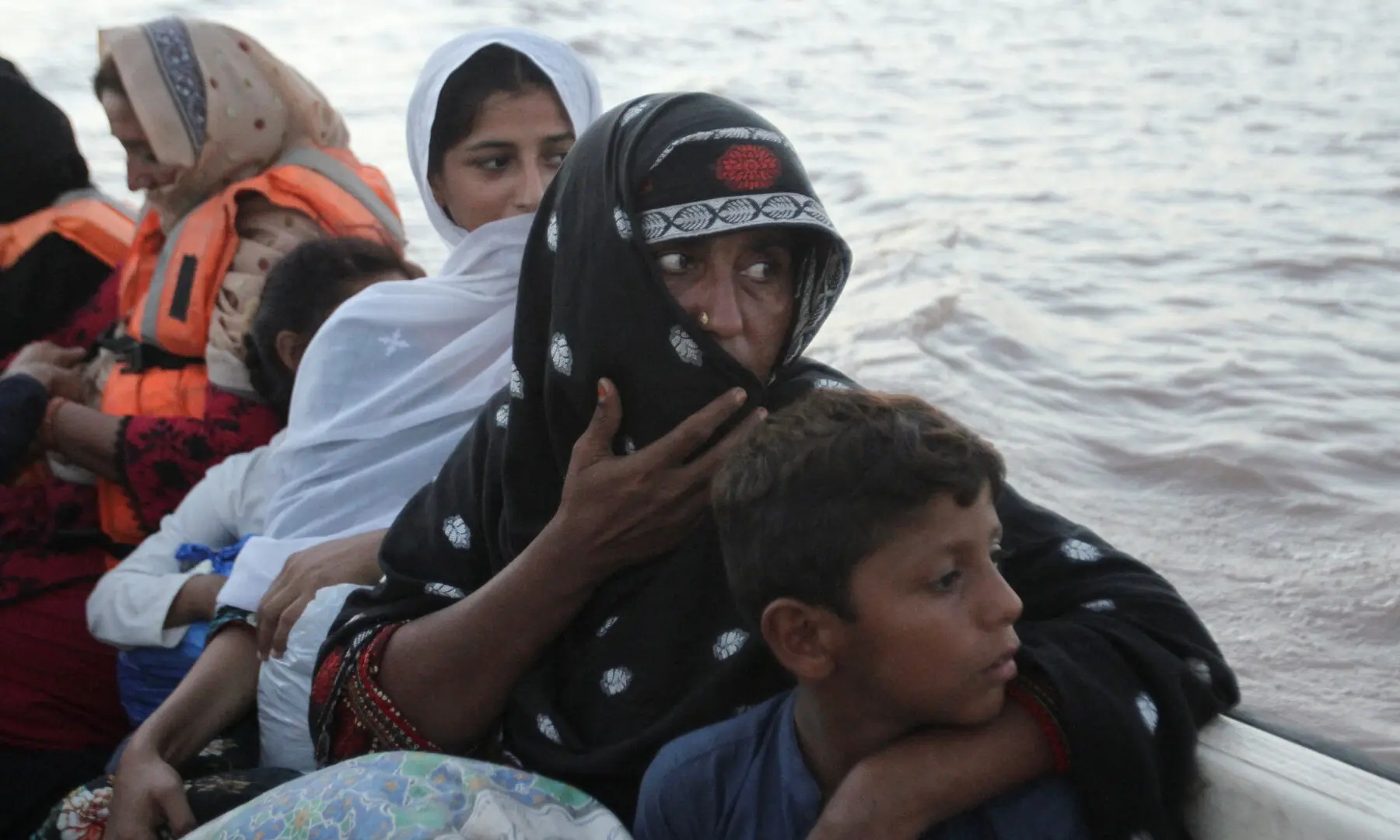  Tasneem Bibi sits with her children in a rescue boat as they evacuate following monsoon rains and rising water levels in the Chenab River, in Basti Khan Bela, on the outskirts of Jalalpur Pirwala, Multan, Sept 10. &mdash; Reuters 