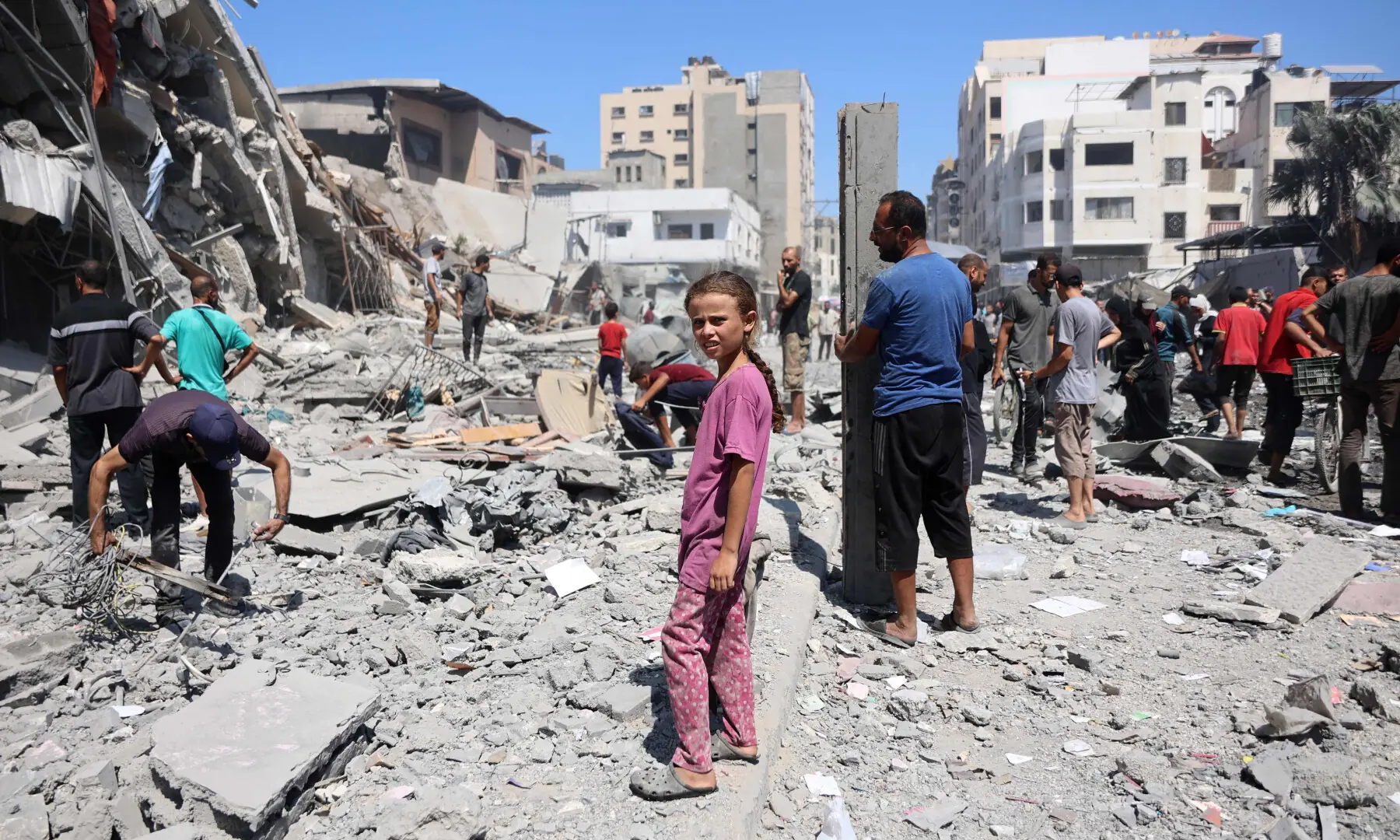 Palestinians walk past a destroyed building after an Israeli strike on Al-Nassr Street in Gaza City on September 12, 2025. — AFP