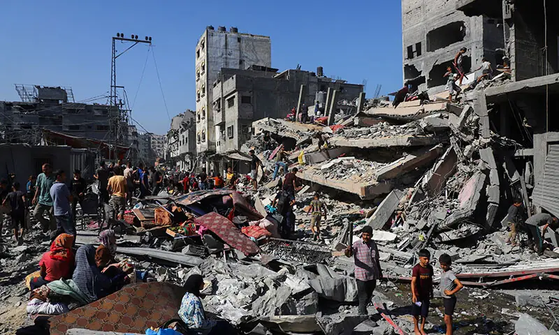 Palestinians inspect the site of Israeli air strikes on houses at the Al-Shati refugee camp in Gaza City on September 12. — Reuters