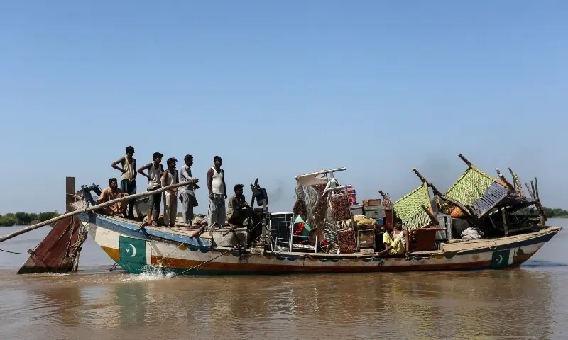 Villagers with their belongings sail in a boat through the floodwaters at Alipur in the Muzaffargarh on September 13. — AFP Villagers with their belongings sail in a boat through the floodwaters at Alipur in the Muzaffargarh on September 13. — AFP