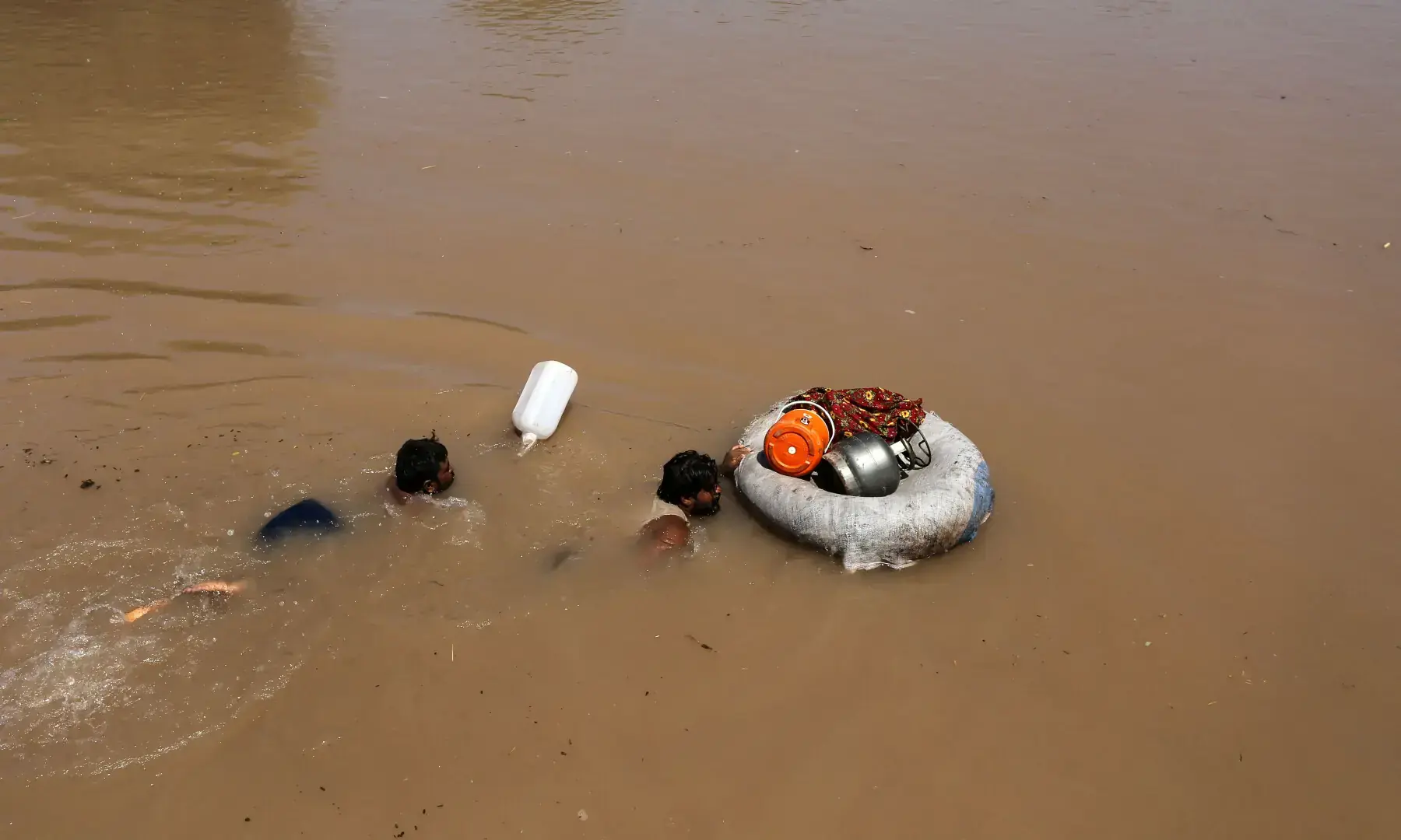 Villagers with their belongings swim through the floodwaters at Alipur, in Muzaffargarh on September 13, 2025.—AFP Villagers with their belongings swim through the floodwaters at Alipur, in Muzaffargarh on September 13, 2025.—AFP
