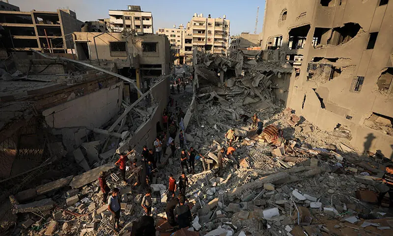 Palestinians inspect damage at the site of Israeli strikes that destroyed Al-Jundi Al-Majhoul residential tower in Gaza City on September 15. — Reuters