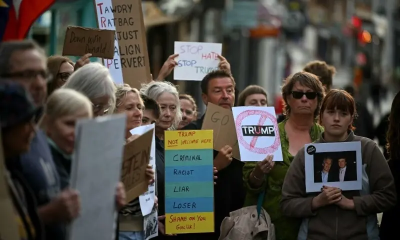 Demonstrators hold placards during a protest against the forthcoming State Visit of US President Donald Trump, outside Windsor Castle in Windsor on September 16. &mdash; AFP