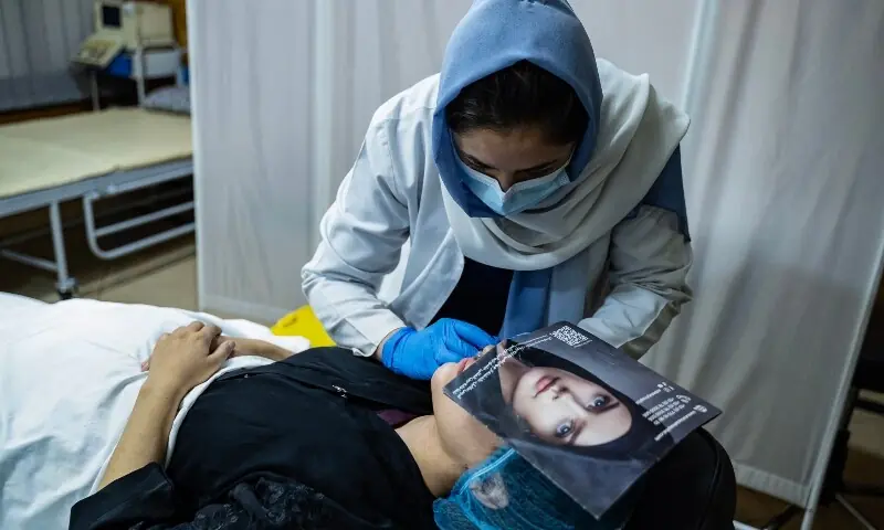 In this photograph taken on August 13, 2025, a member of the medical staff injects fillers into an Afghan women&rsquo;s lips at a beauty clinic in Kabul. &mdash; AFP