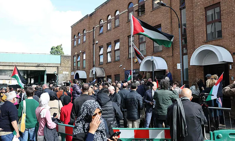 People attend a Palestinian flag-raising ceremony outside the Palestine Mission to the UK, in west London on September 22. &mdash; AFP