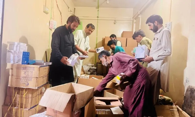 Volunteers pack emergency kits donated by British-Kashmiris for distribution to basic health units across AJK. — Photo by author Volunteers pack emergency kits donated by British-Kashmiris for distribution to basic health units across AJK. — Photo by author