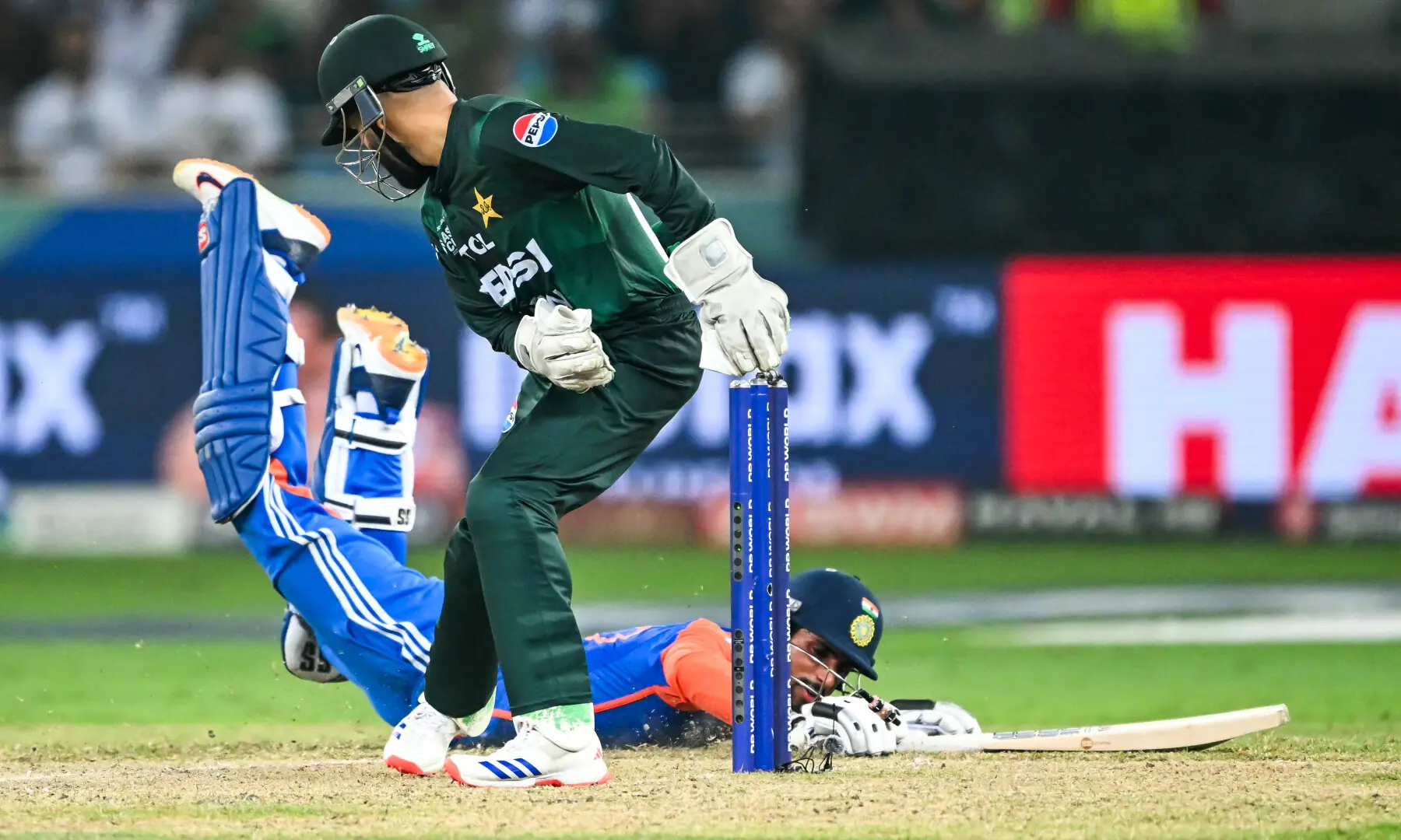 India’s Tilak Varma safely completes a run as Pakistan’s wicketkeeper Mohammad Haris misses a run-out during the Asia Cup 2025 Twenty20 international cricket final match between India and Pakistan at the Dubai International Stadium in Dubai on September 28, 2025. — AFP