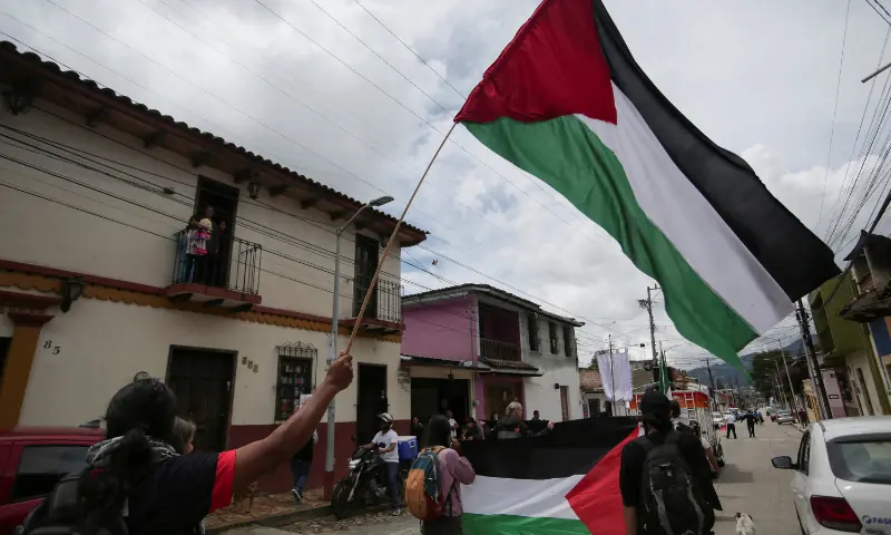 People hold Palestinian flags as faithful participate in a pilgrimage organised by a Catholic Church to pray for peace amid the ongoing conflict in Gaza, in San Cristobal de Las Casas, Chiapas, Mexico, on September 28, 2025. &mdash; Reuters