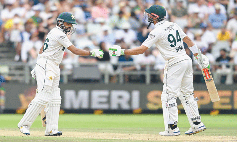 Pakistan batter Babar Azam (L) bumps fists with captain Shan Masood during the second Test against South Africa at Newlands on January 5, 2025. &mdash; AFP/File