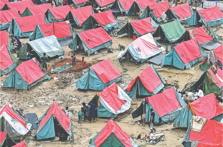 PEOPLE displaced by floods settle in a makeshift relief camp on the outskirts of Lahore.&mdash;AFP