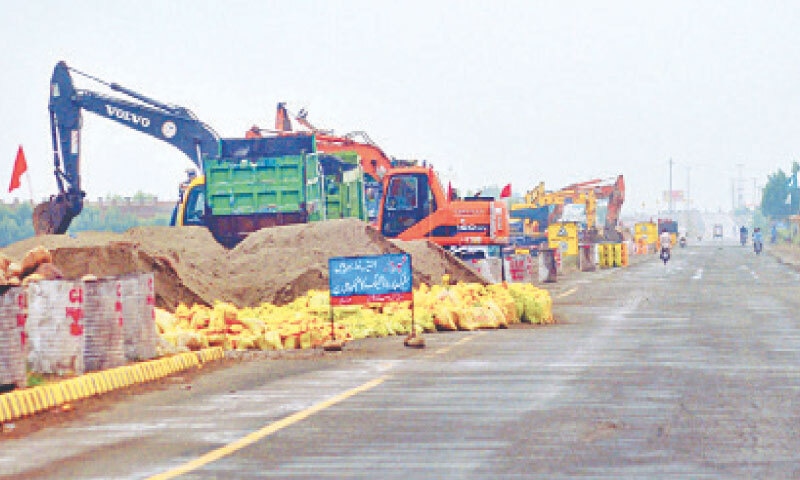  MULTAN: Heavy machinery is being deployed to raise protective dykes, with soil and sandbags, near Head Muhammad Wala.—APP 