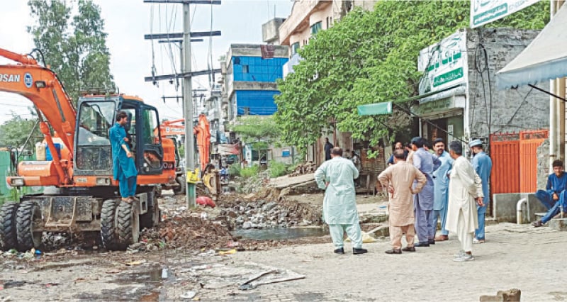 Gujrat: Concrete slabs being removed from a drain along the GT Road near Shah Hussain locality. &mdash; Dawn