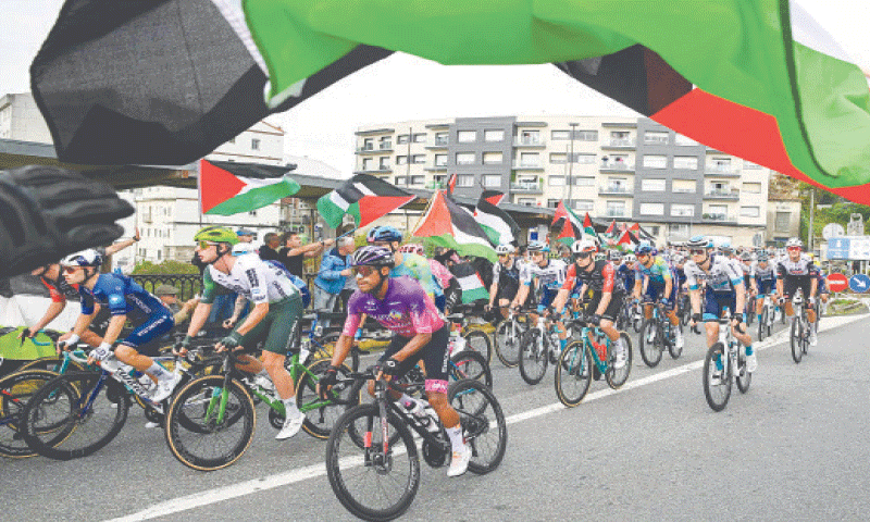 PRO-PALESTINIAN protesters wave flags and shout as the peloton rides by in Poio during the 16th stage of the Vuelta a Espana on Tuesday.&mdash;AFP