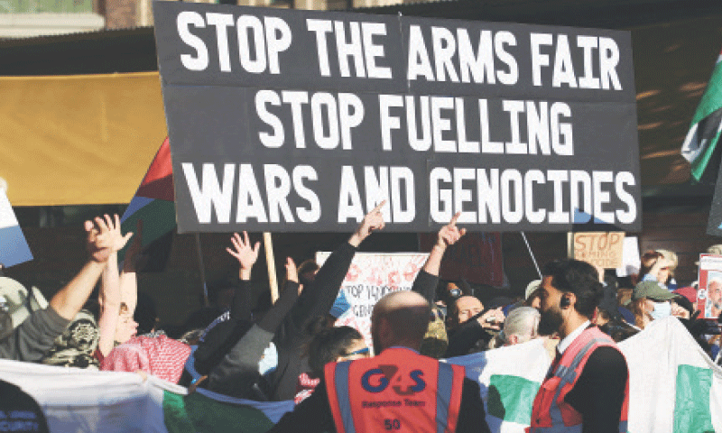 Demonstrators hold up signs and Palestinian flags during a protest in London against Britain&rsquo;s decision to continue arms exports to Israel.&mdash;Reuters