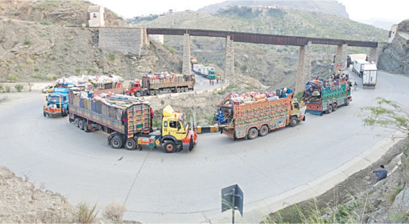 Returning Afghan families with all their personal belongings wait for their turn in a long queue of trucks at Torkham border prior to their repatriation. &mdash; Dawn