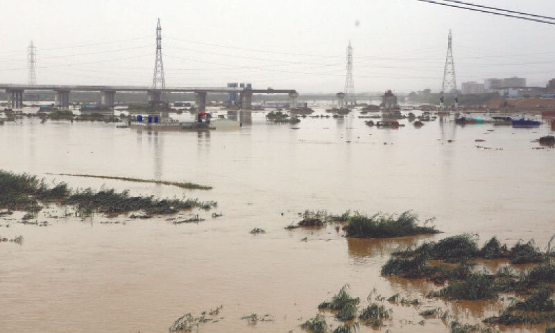 The Korangi causeway, which connects Korangi Industrial Area with the city’s East and South districts, is submerged after the Malir river swelled to an alarming level following heavy rains.—Shakil Adil / White Star The Korangi causeway, which connects Korangi Industrial Area with the city’s East and South districts, is submerged after the Malir river swelled to an alarming level following heavy rains.—Shakil Adil / White Star