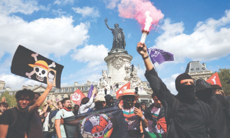 A protester holds a red flare during a demonstration at the Place de la Republique in Paris as part of a countrywide protest movement.&mdash;Reuters