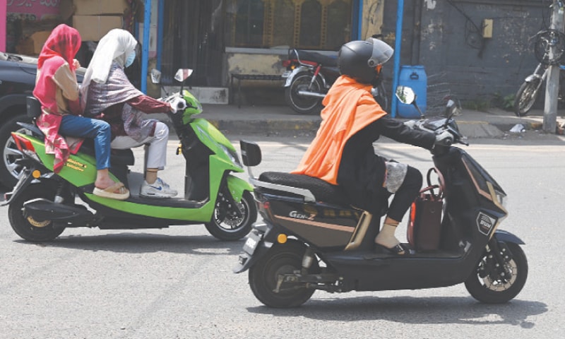 Female bikers make their way along a road. &mdash; White Star