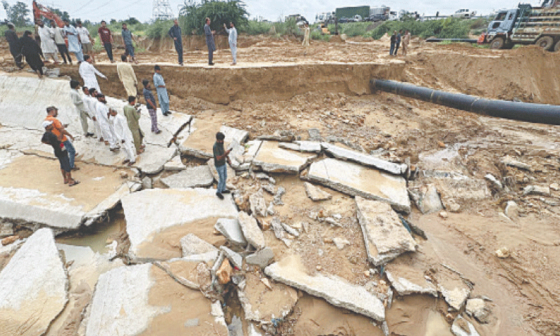 People survey the destruction caused by heavy rains to the new Hub Canal, which was inaugurated by PPP Chairman Bilawal Bhutto-Zardari less than a month ago. Opposition parties have criticised the Sindh government for its alleged substandard construction, with Pakistan Tehreek-i-Insaf&rsquo;s Haleem Adil Sheikh, who visited the canal on Thursday, demanding an independent commission to probe the collapse of the Rs12bn project. Karachi Water and Sewerage Corporation officials said the rains and floodwater severely damaged the old and new canals, and repair work has already begun. However, water supply