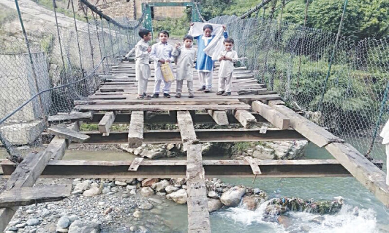 Children stand perilously close to the damaged portion of the suspension bridge in Shahpur area of Shangla. — Dawn Children stand perilously close to the damaged portion of the suspension bridge in Shahpur area of Shangla. — Dawn