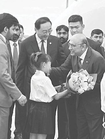 CHENGDU: A girl presents a bouquet to President Asif Ali Zardari upon his arrival in China.&mdash;APP