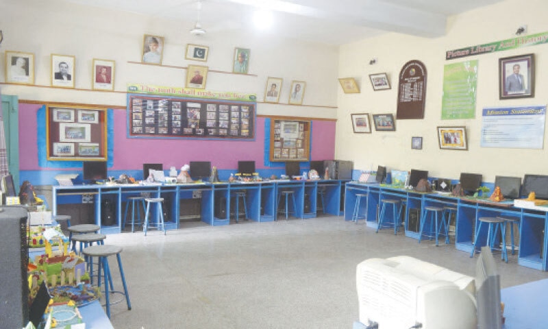 A computer lab room where walls have been decorated with pictures of old students and teachers.