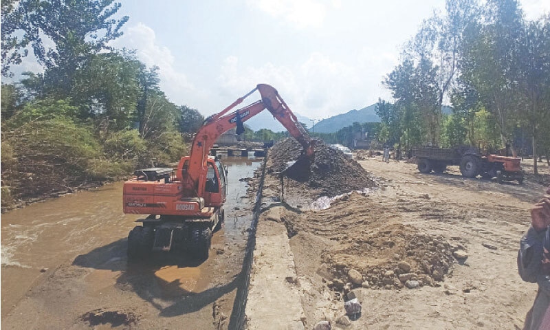 AN excavator dredging the Kawga Khwar, near Pir Baba Bazaar in Buner. —Dawn AN excavator dredging the Kawga Khwar, near Pir Baba Bazaar in Buner. —Dawn