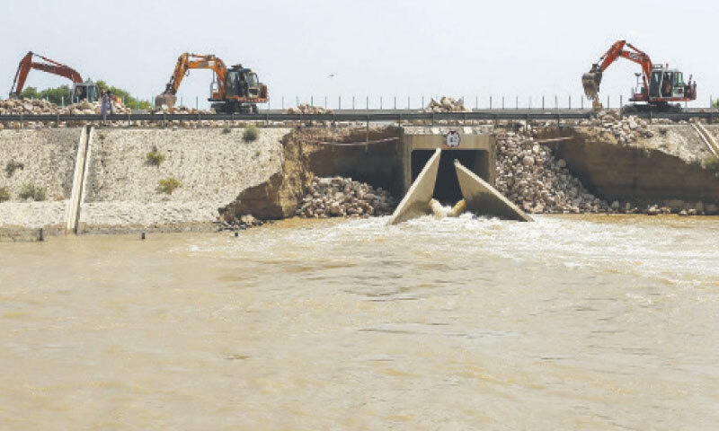 Authorities use excavators to fill a damaged section of the M-5 motorway with rocks to prevent floodwater from entering Jalalpur Pirwala after the Chenab River overflowed.&mdash;AFP