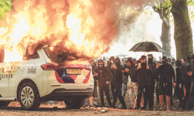 PROTESTERS set a police car on fire during the demonstration in The Hague.&mdash;AFP