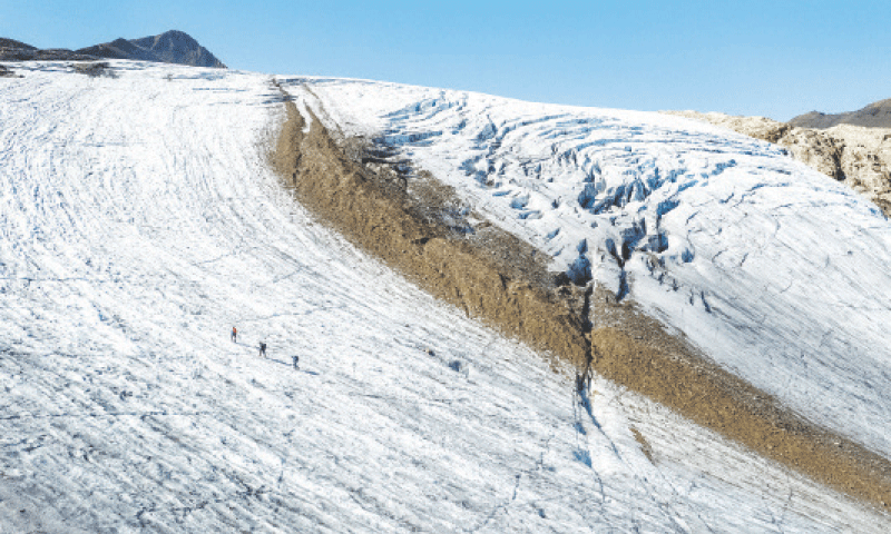 THIS Sept 11 file picture shows glaciologists walking over a glacier on a warm summer day in Obergoms, Switzerland.—Reuters THIS Sept 11 file picture shows glaciologists walking over a glacier on a warm summer day in Obergoms, Switzerland.—Reuters