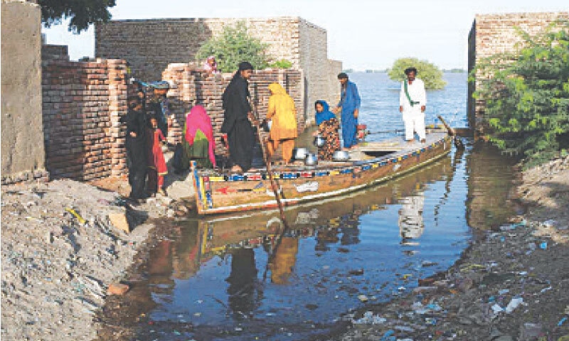 JAMSHORO: Residents of Unnarpur board a boat after floodwaters entered their locality.&mdash;Umair Ali