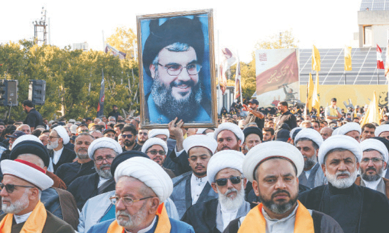 A CLERIC holds a picture of Hassan Nasrallah during a ceremony to mark his first death anniversary.&mdash;AFP