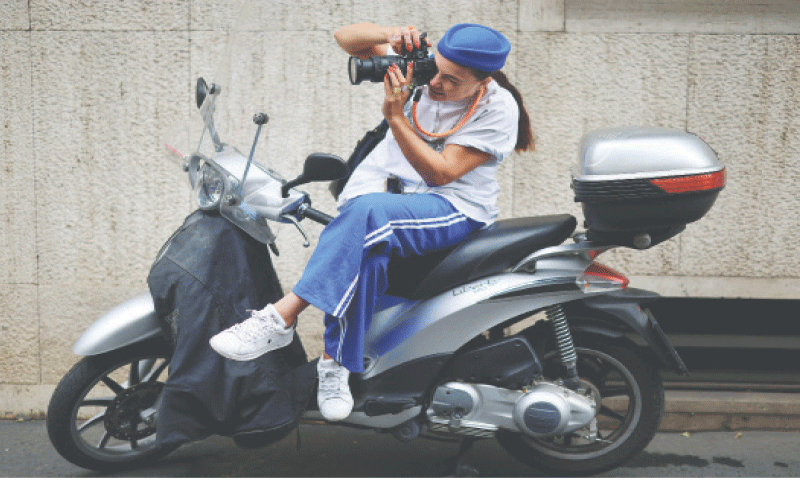A WOMAN takes a picture on a scooter outside the venue of Dolce & Gabbana
Spring-Summer show in Milan.—Reuters A WOMAN takes a picture on a scooter outside the venue of Dolce & Gabbana
Spring-Summer show in Milan.—Reuters