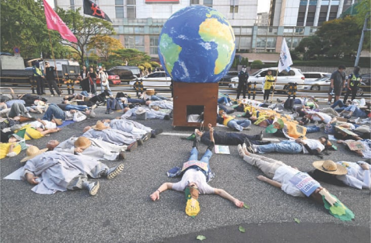  SEOUL: Protesters stage a &lsquo;die-in&rsquo; performance during a rally for Climate Justice on Saturday. Tens of thousands of people took to the streets of South Korea&rsquo;s capital demanding the government set ambitious greenhouse gas reduction targets, just days after President Lee Jae Myung addressed the UNGA, where US President Donald Trump dismissed climate change as &lsquo;the greatest con job&rsquo; in the world.&mdash;AFP 