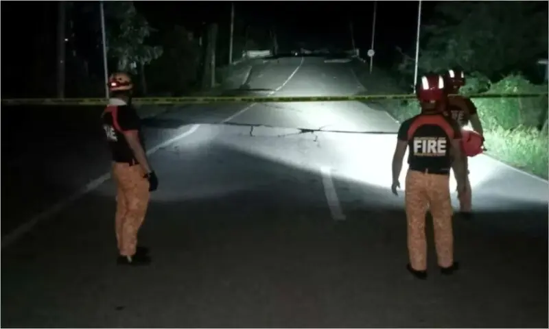 Rescue personnel stand in front of a crack in a road caused by a magnitude 6.9 quake, in Daanbantayan, Cebu Province, Philippines, October 1, 2025.  &mdash; Municipality of Daanbantayan/Handout via Reuters.