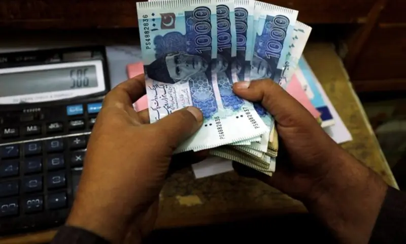 A trader counts Pakistani rupee notes at a currency exchange booth in Peshawar, Pakistan, on December 3, 2018. &mdash; Reuters/File