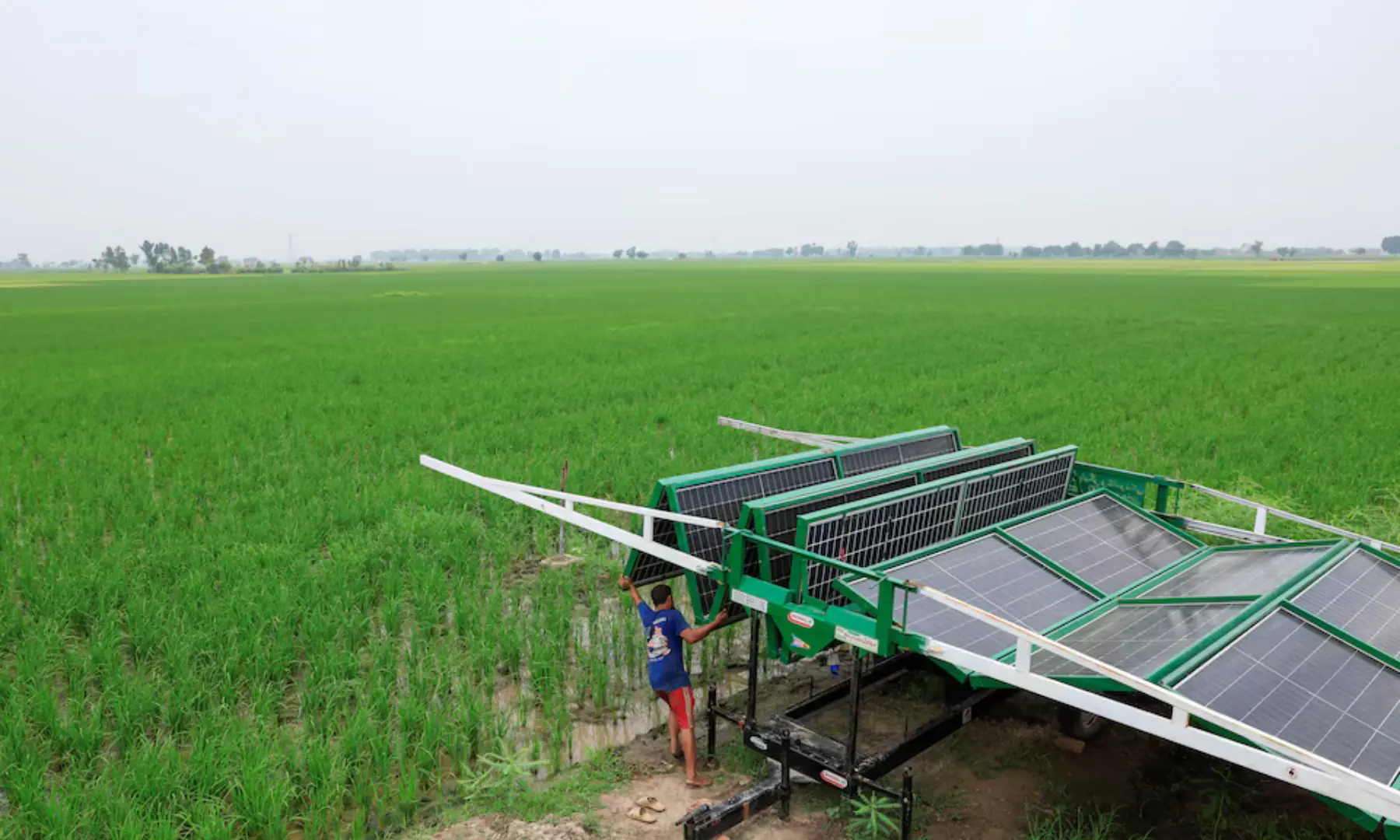 A worker installs a folding solar panel unit, to run a tube well, the motorised pump that taps groundwater, in a rice field in Muridke, Sheikhupura District in Punjab, on August 12. &mdash; Reuters