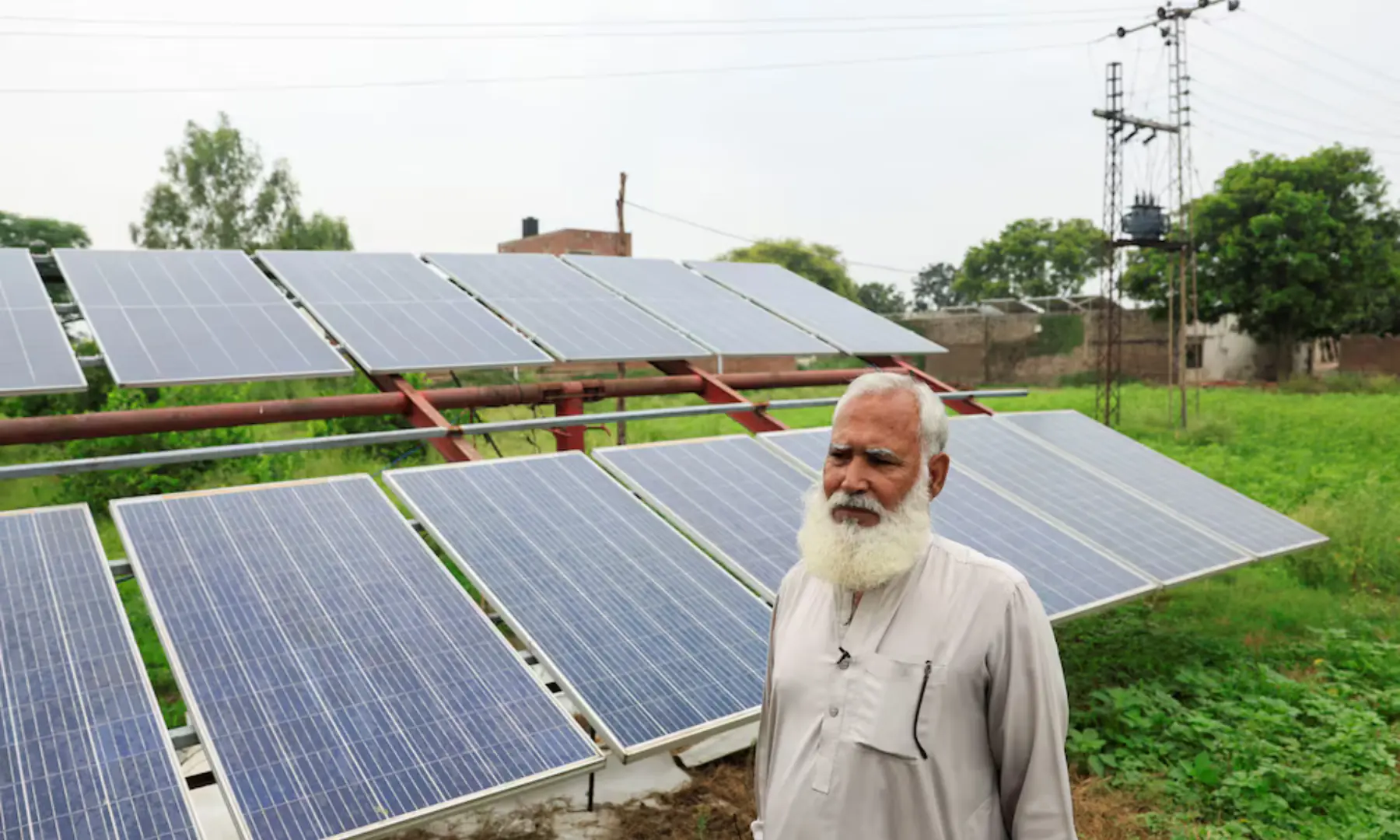 Mohammad Naseem, a farmer, stands beside his solar panels, installed to run a tube well, the motorised pump that tap groundwater, amid a rice field, in Muridke, Sheikhupura District in Punjab, on August 12. &mdash; Reuters