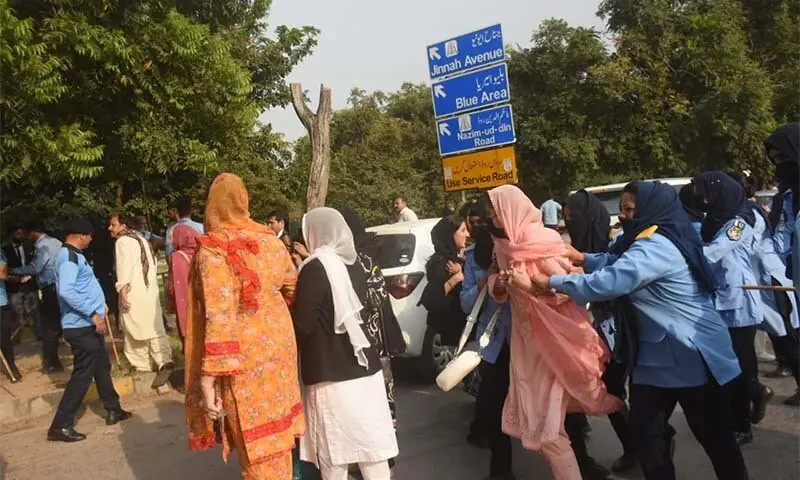 People are led away by police during a raid on the National Press Club in Islamabad on October 2. — Dawn
