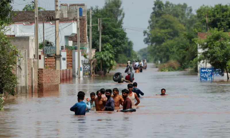 Residents wade through a flooded road, following monsoon rains and rising water levels in Qadirabad village near Chenab River in Punjab, on August 28, 2025. &mdash; Reuters/File