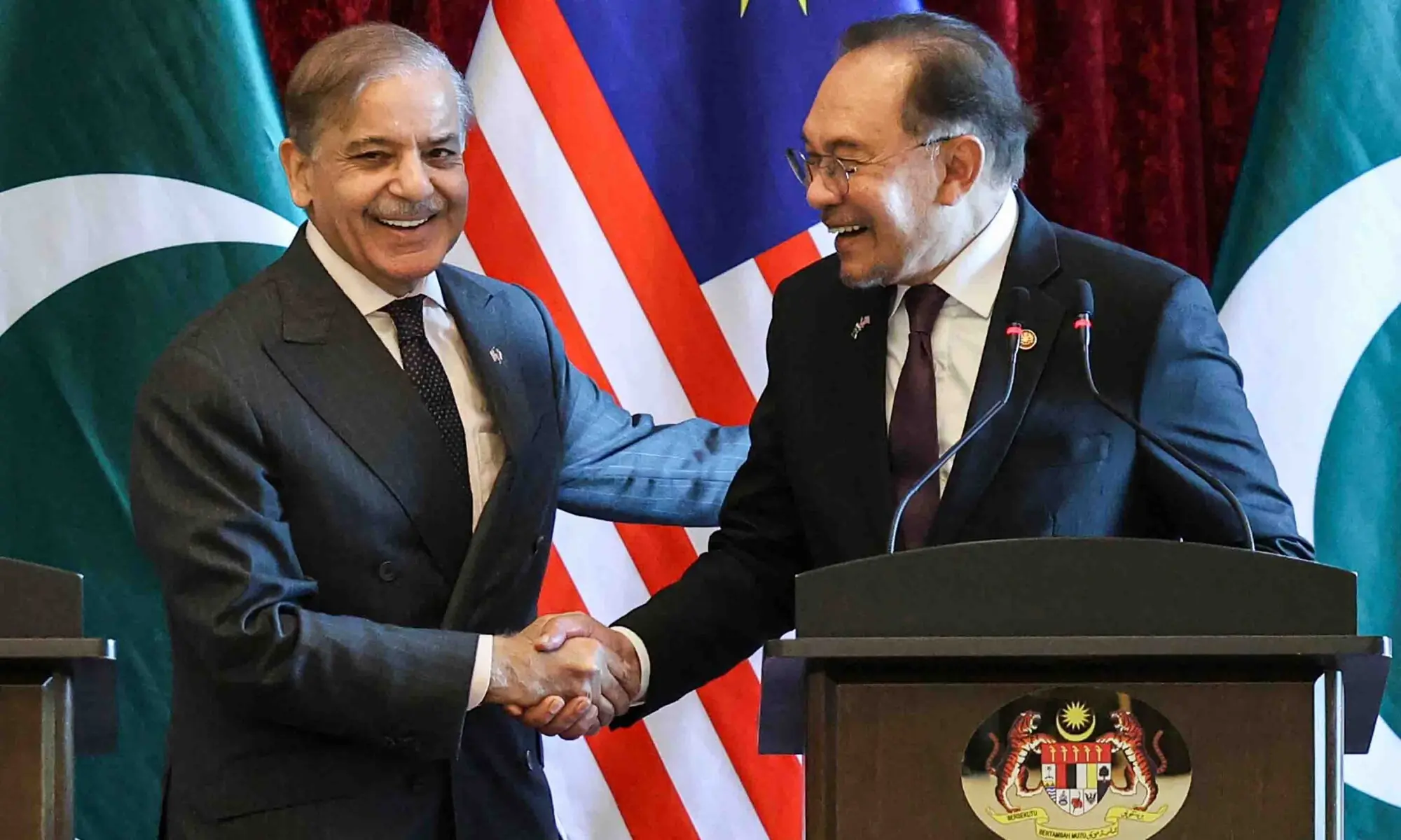 Prime Minister Shehbaz Sharif and Malaysia&rsquo;s Prime Minister Anwar Ibrahim (R) shake hands as they attend a press conference during a meeting in Putrajaya on October 6. &mdash; AFP