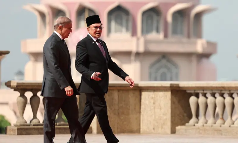 Prime Minister Shehbaz Sharif and Malaysia&rsquo;s Prime Minister Anwar Ibrahim walk during a meeting in Putrajaya on October 6. &mdash; AFP