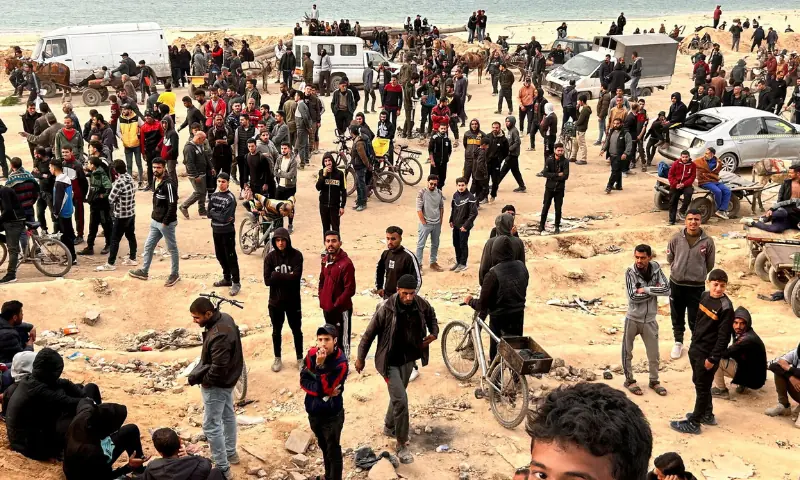 Palestinians gather as they wait for trucks carrying bags of flour to arrive, near an Israeli checkpoint, amid the conflict between Israel and Hamas, in Gaza City, on February 26, 2024. — Reuters