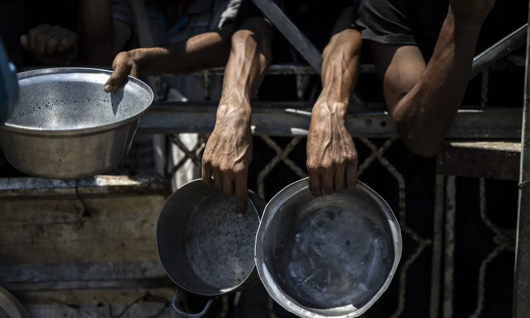   Palestinians wait for food that was distributed by a charity organization in Gaza City on July 25. — Aandolu Agency  