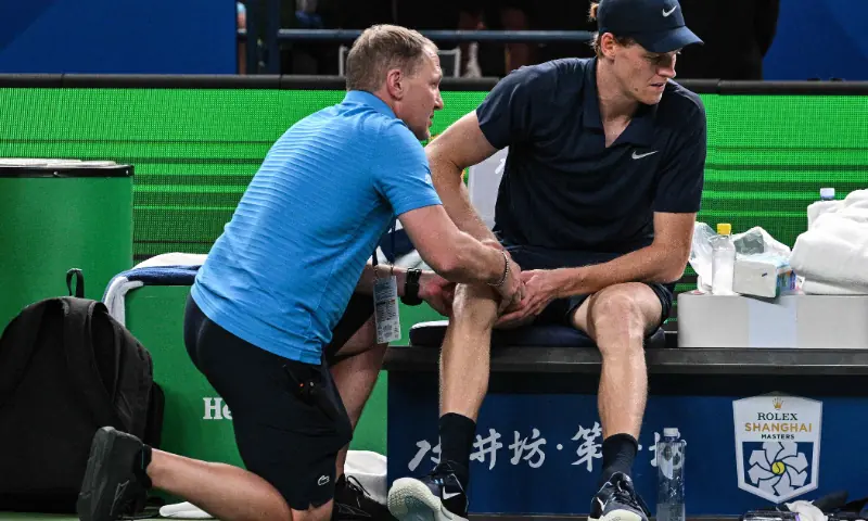 Italy&rsquo;s Jannik Sinner (R) reacts on the bench as he receives medical attention during his men&rsquo;s singles match against Netherlands&rsquo; Tallon Griekspoor at the Shanghai Masters tennis tournament in Shanghai on October 6, 2025. &mdash; AFP