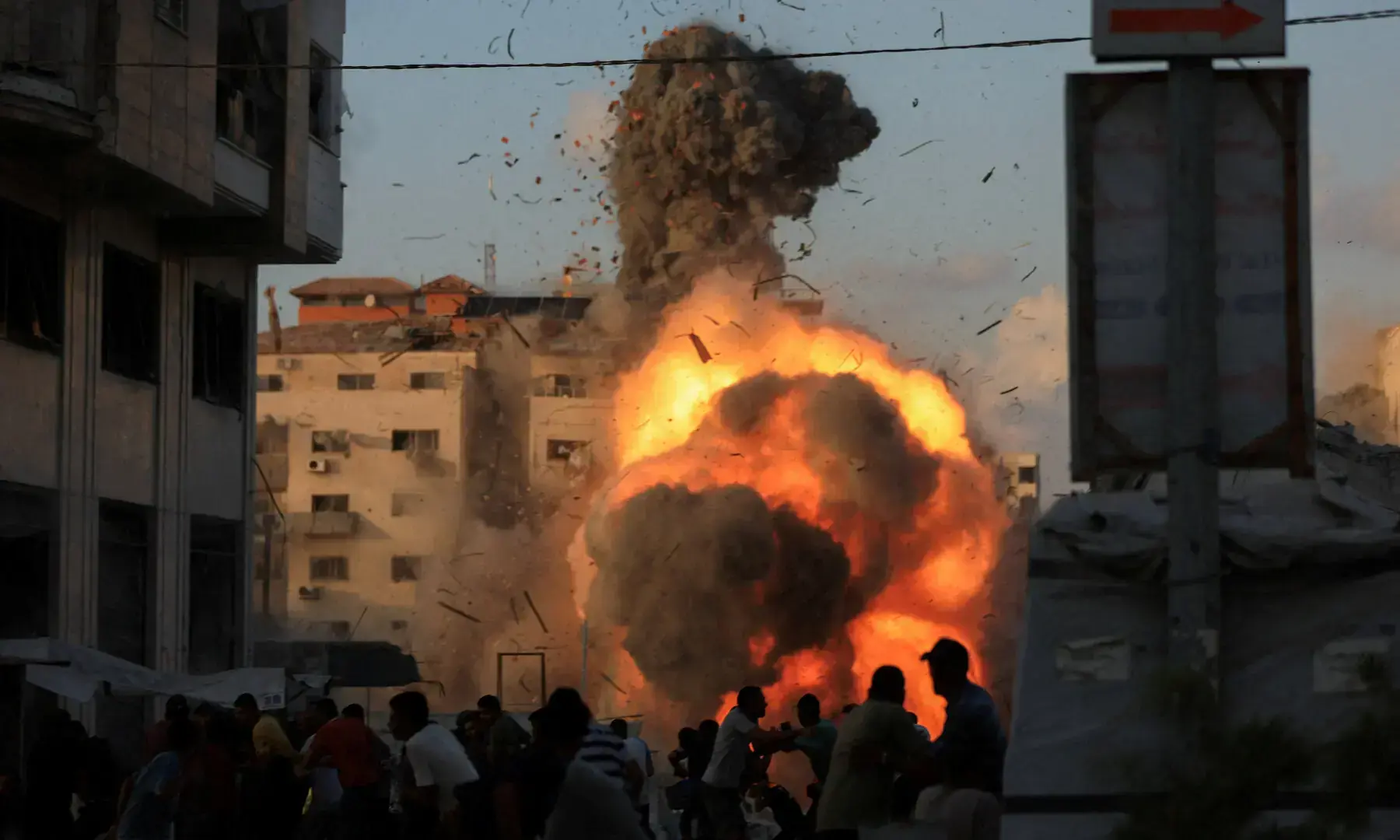 Palestinians react, as smoke and flames rise while a residential building collapses after an Israeli air strike, in Gaza City on September 7, 2025. &mdash; Reuters/Dawoud Abu Alkas