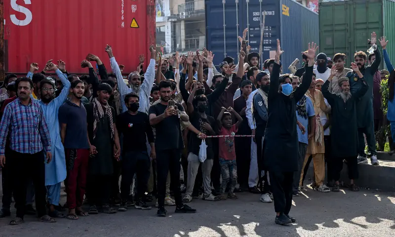 Activists of the Tehreek-e-Labbaik Pakistan (TLP) party shout slogans near their party headquarters, as authorities blocked the road with shipping containers, in Lahore on October 9, 2025, ahead of their pro-Palestinian march towards Islamabad. &mdash; AFP