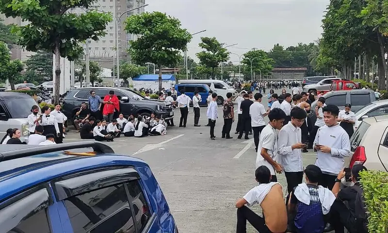 Employees at a shopping mall gather outside the building in Davao City, on the southern island of Mindanao on October 10, after a 7.4-magnitude earthquake struck off the southern Philippines. &mdash; AFP